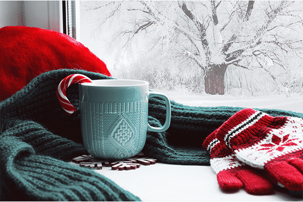 Winter scene with a candy cane in coffee cup in window sill